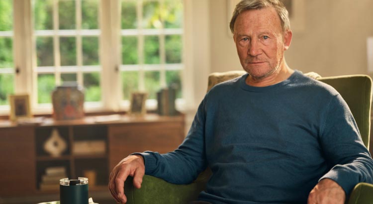 Male patient sitting in an armchair. Actor portrayal
